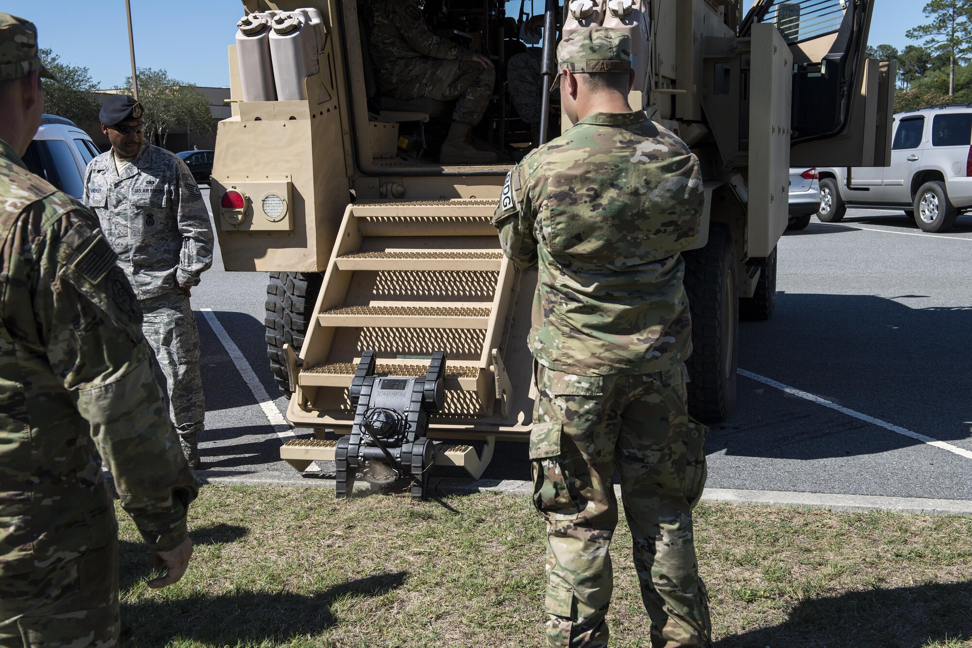 Airmen watch a remote controlled tactical vehicle from the Lowndes County Sherriff’s office attempt to enter a mine-resistant ambush protected vehicle during the Police Week car show, May 16, 2017, at Moody Air Force Base, Ga. Different law enforcement vehicles were put on display for attendees to climb in and ask questions about. (U.S. Air Force photo Senior Airman Janiqua P. Robinson)