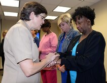 The U.S. Navy Chief of Chaplains, Rear Adm. Margaret Grun Kibben, left, blesses the hands of Naval Health Clinic Charleston nurse, Brenda Sales, during a "Blessing of the Hands" ceremony May 8 at NHCC located on Joint Base Charleston - Weapons Station, in celebration of National Nurses Week May 6-12. The "Blessing of the Hands" ceremony, a hospital tradition practiced around the world during Nurses Week, honors nurses who use their hands in many ways to bring healing to patients. 