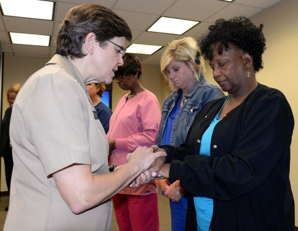 The U.S. Navy Chief of Chaplains, Rear Adm. Margaret Grun Kibben, left, blesses the hands of Naval Health Clinic Charleston nurse, Brenda Sales, during a "Blessing of the Hands" ceremony May 8 at NHCC located on Joint Base Charleston - Weapons Station, in celebration of National Nurses Week May 6-12. The "Blessing of the Hands" ceremony, a hospital tradition practiced around the world during Nurses Week, honors nurses who use their hands in many ways to bring healing to patients. 