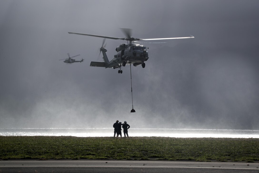 U.S. Navy Sailors assigned to the amphibious assault ship Bonhomme Richard (LHD 6) practice vertical replenishment with a SH-60 Sea Hawk helicopter during the Landing Signalman Enlisted course aboard Marine Corps Base Hawaii, May 10, 2017. The course provides the Sailors the skills they need to perform the tasks essential to flight deck operations. (U.S. Marine Corps photo by Gunnery Sgt Ezekiel R. Kitandwe)