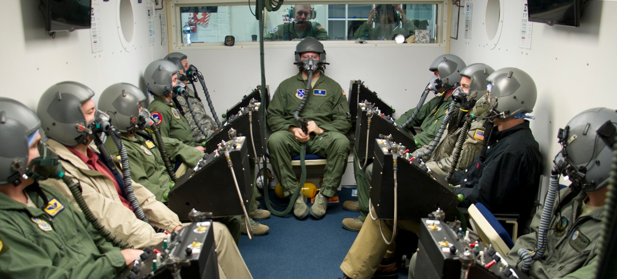Senior Airman Christopher Connolly (center sitting), 779th Aerospace Medical Squadron physiologist, and students await the beginning of their altitude training course while inside an enclosed chamber March 16, 2017, at Joint Base Andrews, Md. All of the students were undergoing refresher training, required every five years, to test their ability to identify how their bodies reacted in an environment with varying levels of air pressure. (U.S. Air Force photo by Staff Sgt. Joe Yanik)