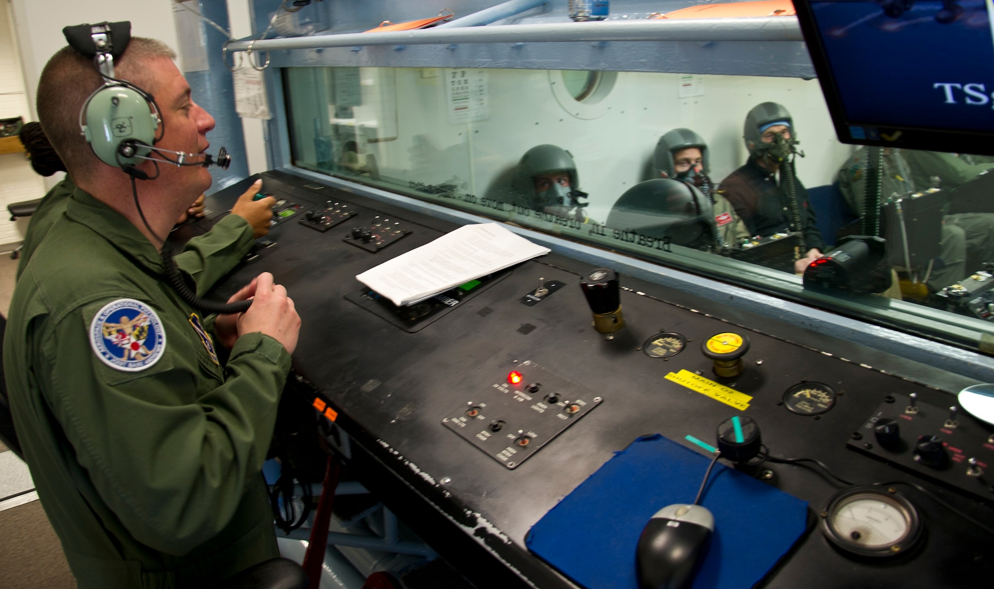 Tech. Sgt. Nicholas Haight (left), 779th Aerospace Medical Squadron flight chief, explains hypoxia symptoms to military and civilian personnel sitting inside an altitude chamber during flight simulation training March 16, 2017, at Joint Base Andrews, Md. Later in the training, the students were exposed to varying levels of air pressure as they would experience at different altitudes. (U.S. Air Force photo by Staff Sgt. Joe Yanik)