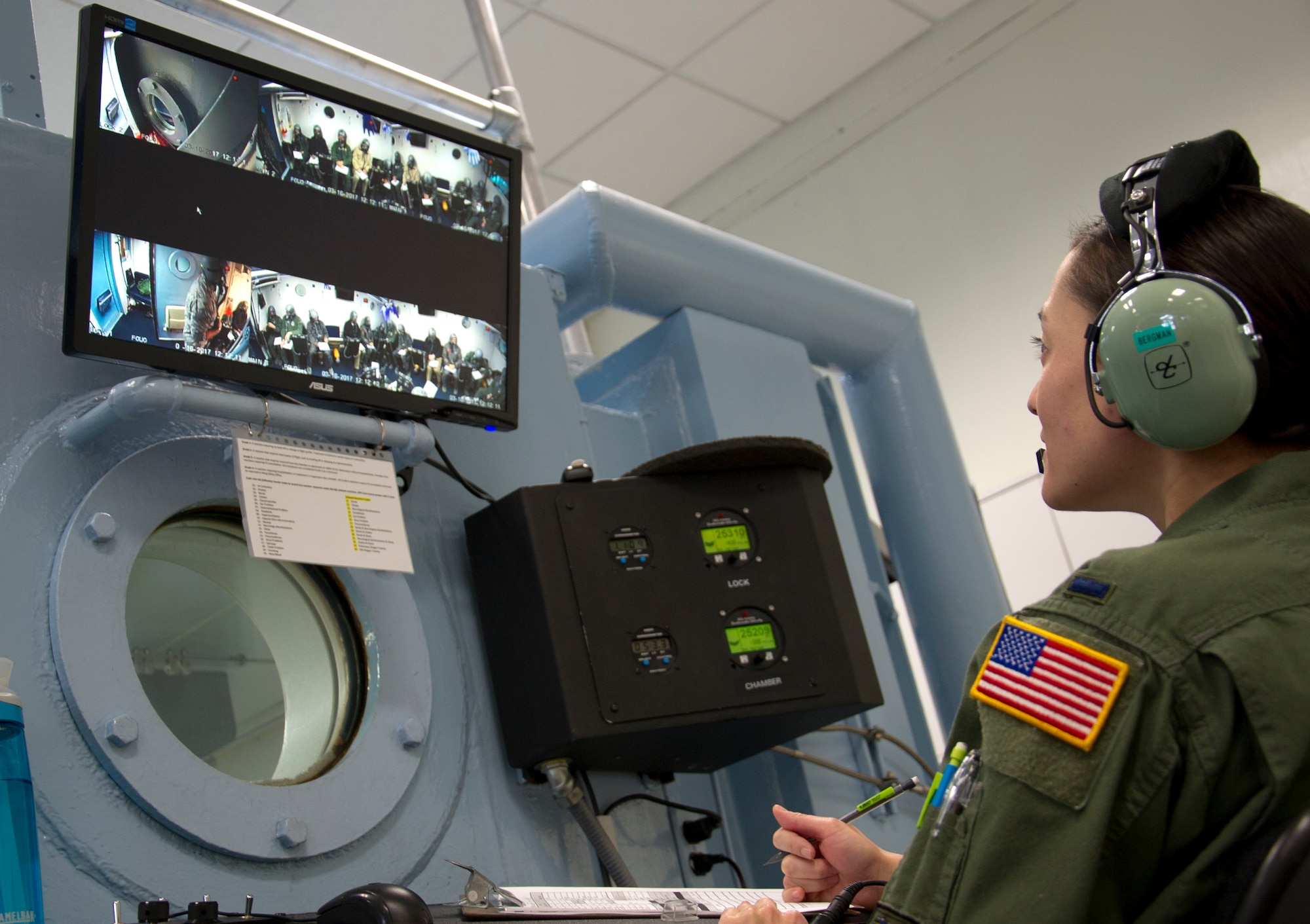 1st Lt. Alethea Bergman, 779th Aerospace Medical Squadron operations chief, monitors the altitude chamber’s communications systems and the behavior of the students as they train in an enclosed altitude chamber March 16, 2017 at Joint Base Andrews, Md. From outside the chamber, she also kept watch on the amount of time the students were exposed to varying levels of air pressure without wearing their oxygen masks.  (U.S. Air Force photo by Staff Sgt. Joe Yanik)