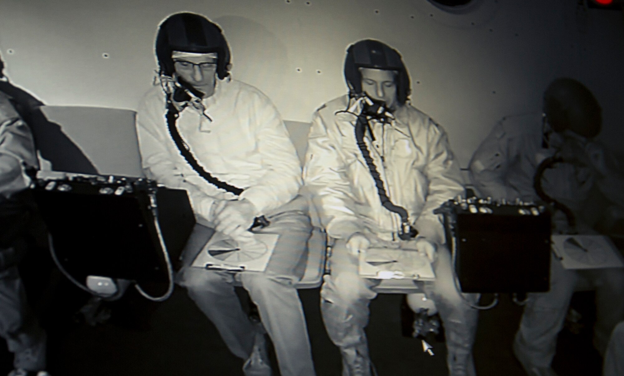 Altitude training students, David Kinsella (left) and Eric Kaufman, perform a visual acuity exercise using color wheel charts in a darkened, enclosed altitude chamber March 16, 2017 at Joint Base Andrews, Md. The exercise was one of several during the flight simulation training course that tested students' ability to identify how their bodies reacted in an environment with varying levels of air pressure. (U.S. Air Force photo by Staff Sgt. Joe Yanik)