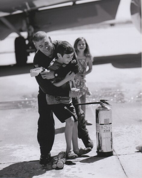 Chief Master Sgt. Shawn Hughes, currently 22nd Air Refueling Wing command chief, hugs his son, Sean, in June 2013, at Edwards Air Force Base, Calif. after his fini-flight. Hughes will retire June 1, 2017, after 30 years of service in the Air Force. (Courtesy photo)
