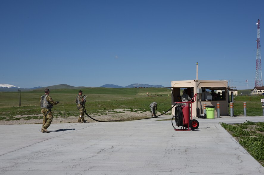 Aircrew from the 40th Helicopter Squadron work with Tech. Sgt. Nathan Wiley, 10th Missile Squadron facility manager, to return a hose back to a missile field refueler after refueling May 11, 2017, at Malmstrom Air Force Base, Mont. This was the seventh completed missile alert facility helicopter refuel completed at Malmstrom. (U.S. Air Force photo/ Staff Sgt. Delia Marchick)