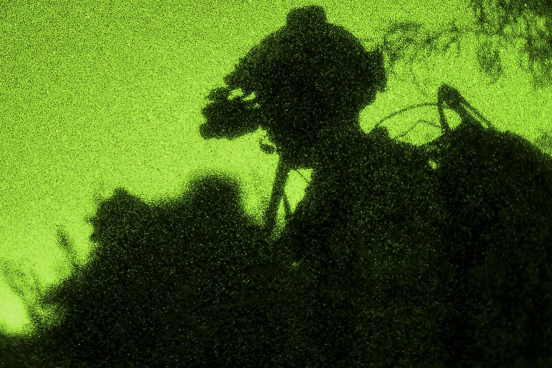 As seen through a night-vision lens, an airman scans his sector member during a training scenario as part of exercise Angel Thunder 17 in Gila Bend, Ariz., May 13, 2017. The airman is assigned to the 58th Rescue Squadron. Air Force photo by Staff Sgt. Sean Martin