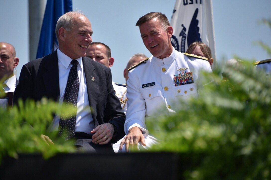 Secretary of Homeland Security John F. Kelly and Coast Guard Commandant Adm. Paul F. Zukunft share a light moment during the 136th U.S. Coast Guard Academy Commencement in New London, Conn., May 17, 2017. Both leaders addressed the graduating class at the ceremony. Coast Guard photo by Petty Officer 2nd Class Patrick Kelley