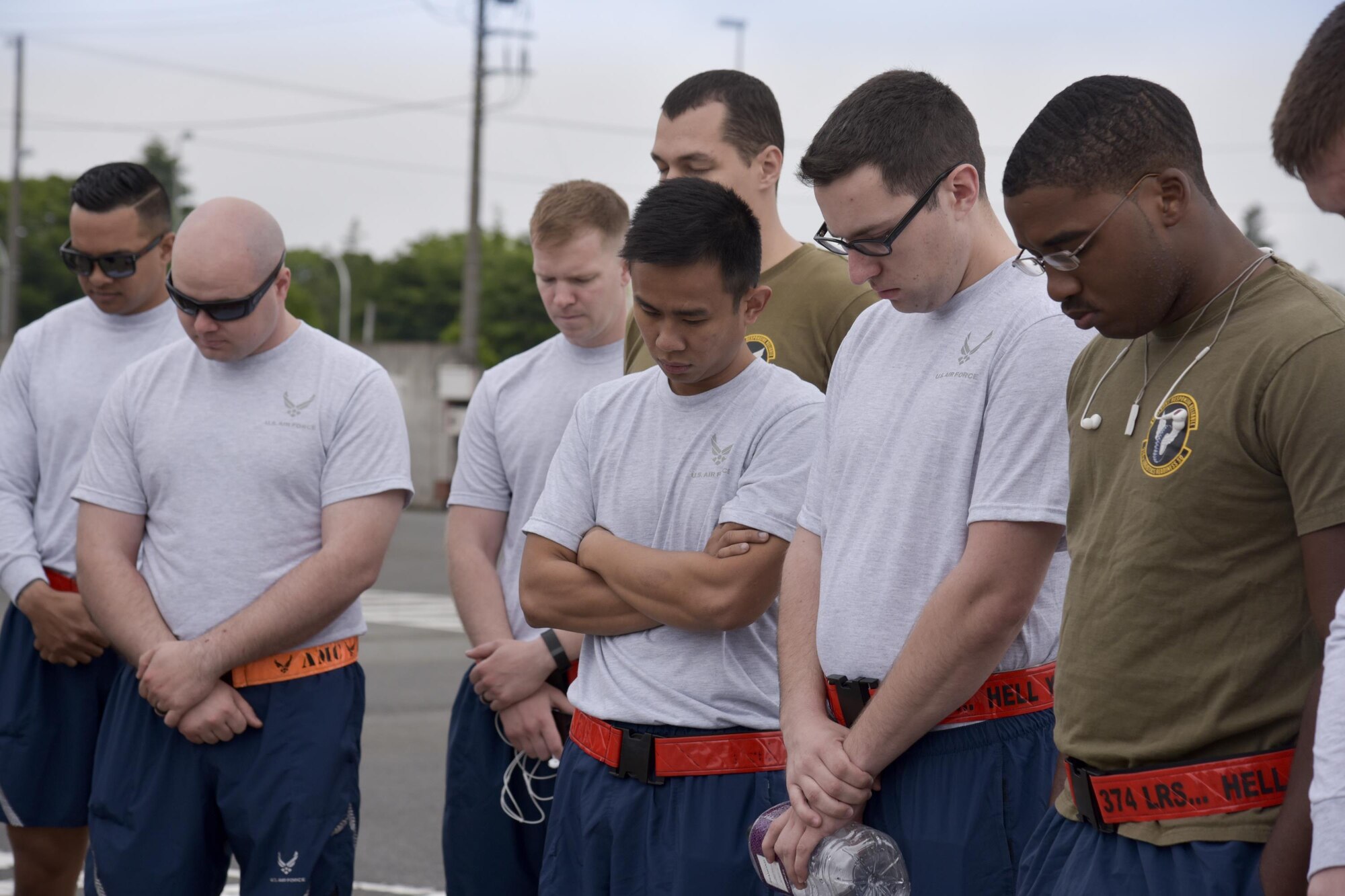 Airmen bow their heads as Capt. Michael McDonald, 374th Airlift Wing chaplain, delivers an invocation before the Port Dawg Memorial Run at Yokota Air Base, Japan, May 15, 2017. The 730th Air Mobility Squadron hosted the Port Dawg Memorial Run in honor of fallen air transportation specialists and brought awareness to Airmen whose job involves many risk factors while also trying to prevent future mishaps. (U.S. Air Force photo by Machiko Arita)