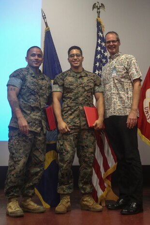 Sgt. Maj. Phillip Billiot, the sergeant major of Headquarters Battalion, Cpl. Paul Franco, a rifleman with 3rd Battalion, 3rd Marine Regiment, and Steve Auerbach, a Solar Ready Vets course instructor, pose for a photo during the SRV graduation ceremony at the theater aboard Marine Corps Base Hawaii on May 11, 2017. The six-week course provided the Marines with basic knowledge of photovoltaic systems and prepared them for the North American Board of Certified Energy Practitioners PV Associates exam. Upon completion of the exam, the Marines will be qualified for solar energy related occupations. (U.S. Marine Corps photo by Lance Cpl. Matthew Kirk)