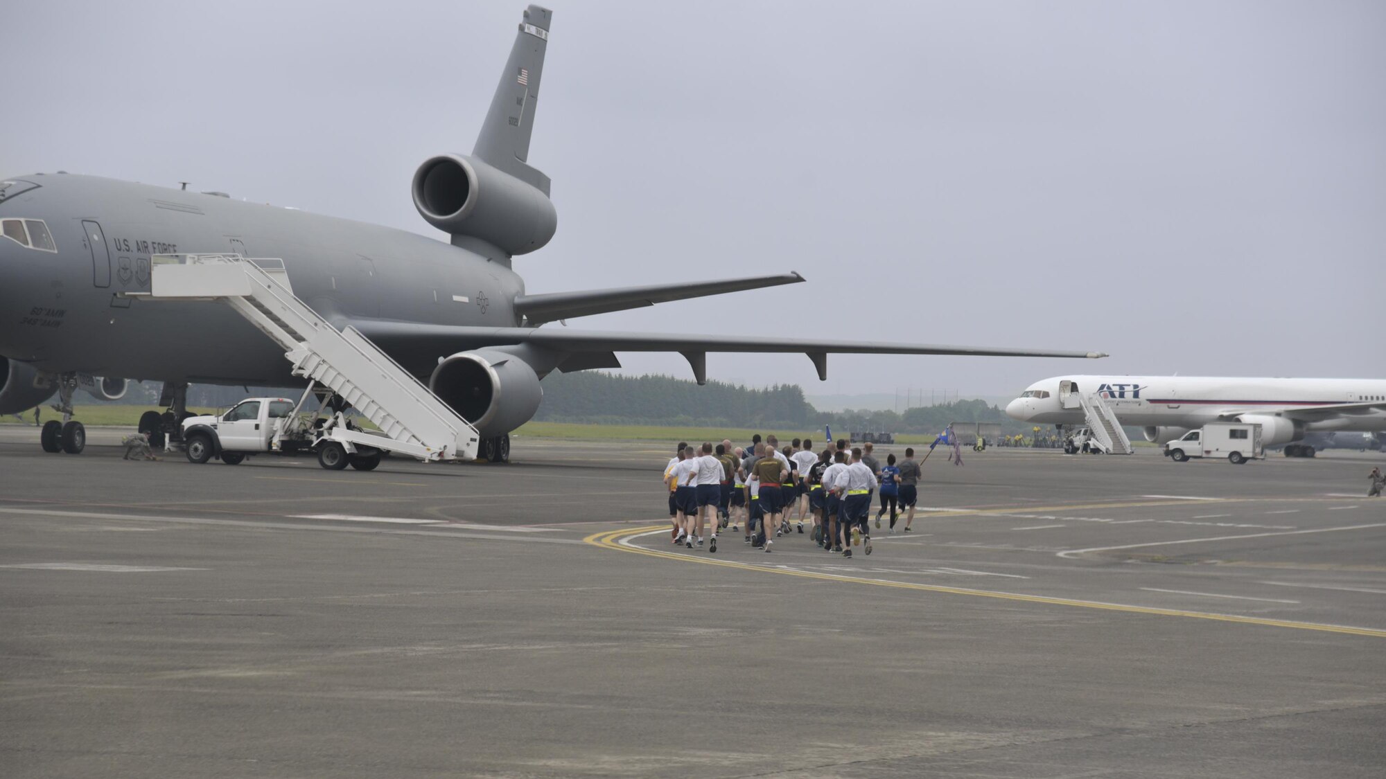 Members from the 730th Air Mobility Squadron, 515th Air Mobility Operations Group, 374th Logistics Readiness Squadron and Navy Overseas Air Cargo Terminal run in formation on the flight line during the Port Dawg Memorial Run at Yokota Air Base, Japan, May 15, 2017. The 730th Air Mobility Squadron hosted the Port Dawg Memorial Run in honor of fallen air transportation specialists and brought awareness to Airmen whose job involves many risk factors while also trying to prevent future mishaps. (U.S. Air Force photo by Machiko Arita)