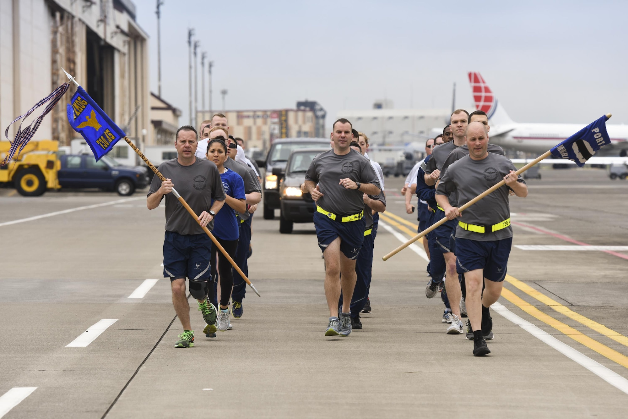 Members from the 730th Air Mobility Squadron, 515th Air Mobility Operations Group, 374th Logistics Readiness Squadron and Navy Overseas Air Cargo Terminal run in formation on the flight line during the Port Dawg Memorial Run at Yokota Air Base, Japan, May 15, 2017. The 730th Air Mobility Squadron hosted the Port Dawg Memorial Run in honor of fallen air transportation specialists and brought awareness to Airmen whose job involves many risk factors while also trying to prevent future mishaps. (U.S. Air Force photo by Machiko Arita)
