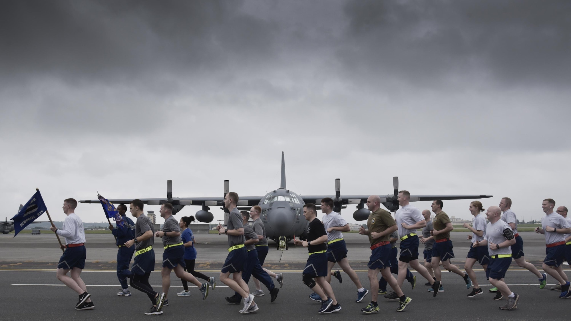 Members from the 730th Air Mobility Squadron, 515th Air Mobility Operations Group, 374th Logistics Readiness Squadron and Navy Overseas Air Cargo Terminal run in formation on the flight line during the Port Dawg Memorial Run at Yokota Air Base, Japan, May 15, 2017. The 730th Air Mobility Squadron hosted the Port Dawg Memorial Run in honor of fallen air transportation specialists and brought awareness to Airmen whose job involves many risk factors while also trying to prevent future mishaps. (U.S. Air Force photo by Machiko Arita)