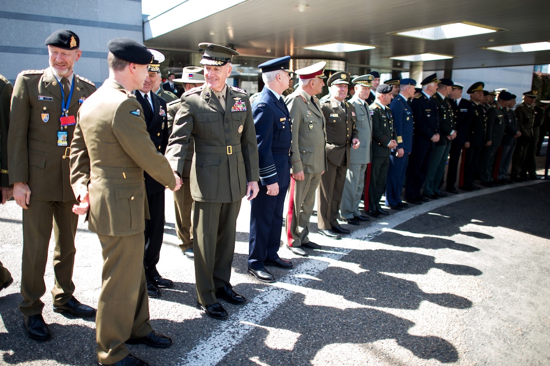 Marine Corps Gen. Joe Dunford, chairman of the Joint Chiefs of Staff, shakes hands with attendees before a wreath-laying ceremony outside NATO Headquarters in Brussels, May 17, 2017. The ceremony honored the fallen service members. DoD photo by Army Sgt. James K. McCann