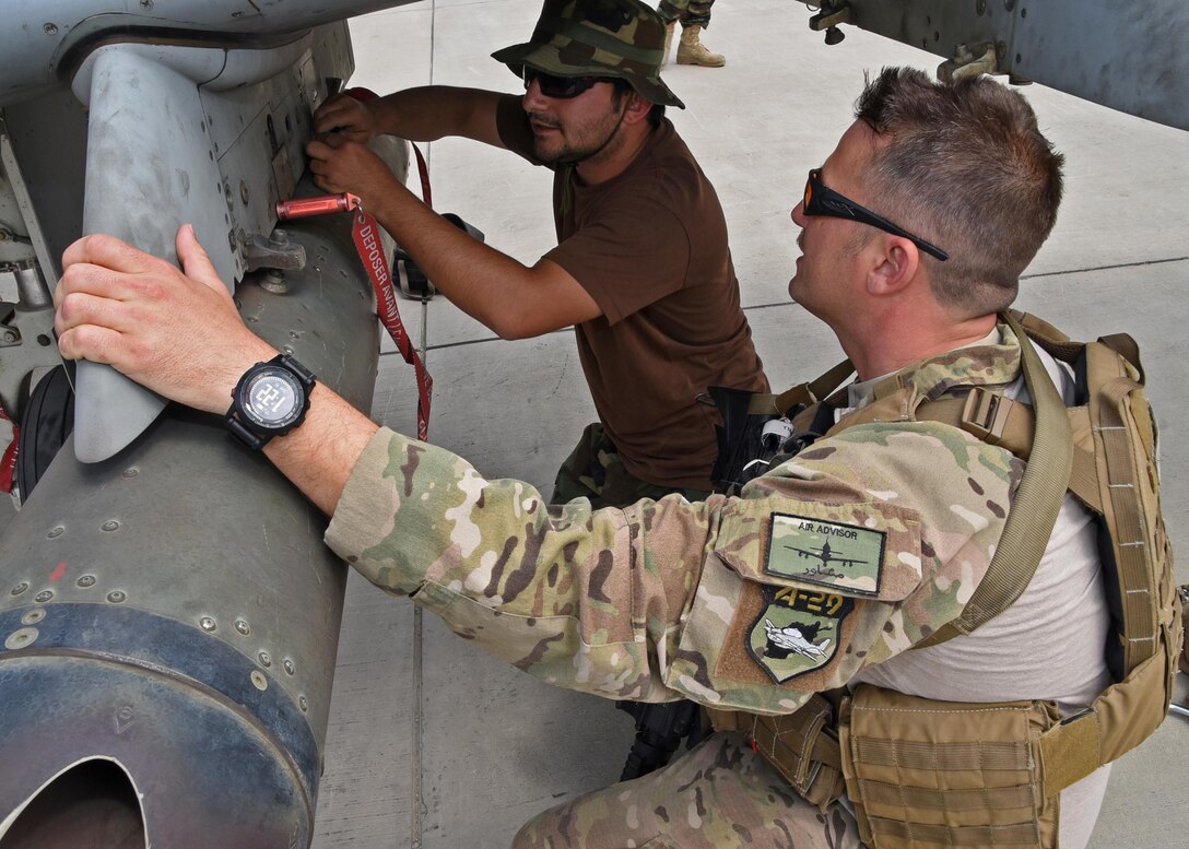 Master Sgt. C.J. Virgil, Train, Advise, Assist Command-Air (TAAC-Air) and 440th Air Expeditionary Advisory Squadron ammunitions advisor, trains with an Afghan Air Force A-29 Super Tucano maintainer on the aircraft at Kabul Air Wing, Afghanistan, May 16, 2017. The AAF A-29 maintainers start their training by attending the Defense Language Institute for six months of English training followed by the International Air Force Academy in San Antonio, Texas to learn basic aircraft maintenance, then to Moody Air Force Base, Ga., for approximately nine months to attend training specific to the A-29. Advisors from TAAC-Air and civilian contractors work with the maintenance crews in Afghanistan for continuation training. (U.S. Air Force photo by Tech. Sgt. Veronica Pierce) 