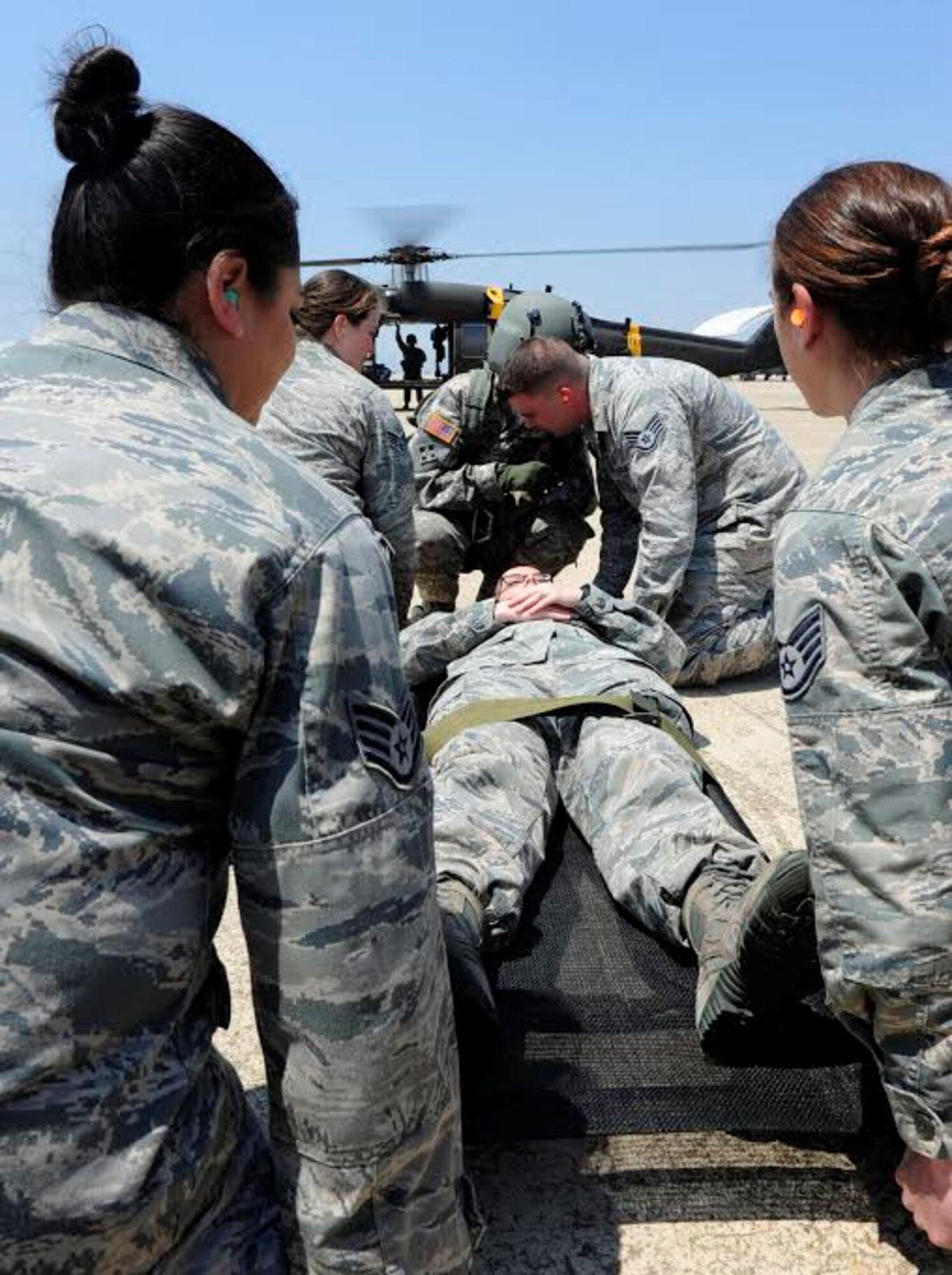 Airmen from the 8th Medical Group prepare to carry a simulated patient to a UH-60 Black Hawk medevac helicopter at Kunsan Air Base, Republic of Korea, May 17, 2017. The purpose of the training was aimed to train medics on loading patients onto a helicopter for dust-off. (U.S. Air Force photo/Staff Sgt. Chelsea Sweatt)