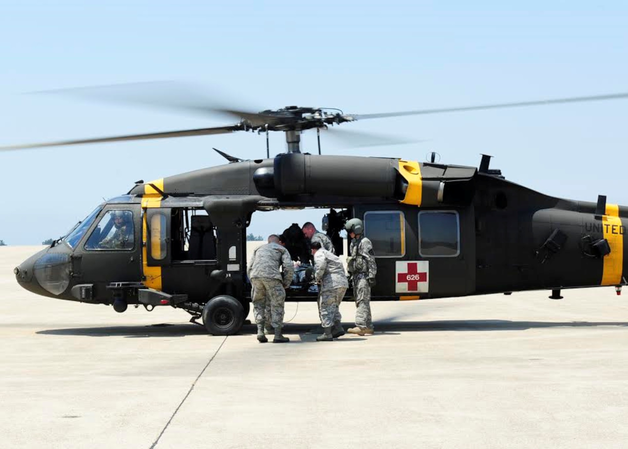 Airmen from the 8th Medical Group carry a simulated patient to a UH-60 Black Hawk medevac helicopter at Kunsan Air Base, Republic of Korea, May 17, 2017. The purpose of the training was aimed to train medics on loading patients onto a helicopter for dust-off. (U.S. Air Force photo/Staff Sgt. Chelsea Sweatt)