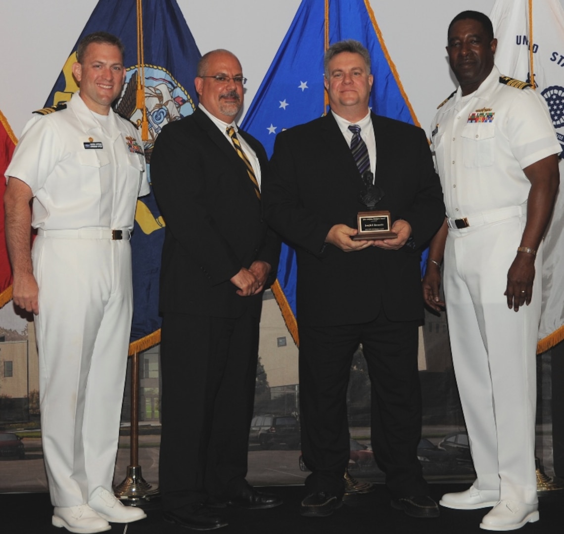 DAHLGREN, Va. (May 17, 2017) - Joseph Berenotto holds  the John Adolphus Dahlgren Award moments after receiving it from Naval Surface Warfare Center Dahlgren Division (NSWCDD) leadership at the command's annual honor awards ceremony. Berenotto was recognized for his outstanding contributions to the Submarine Launched Ballistic Missile program and NSWCDD. "Mr. Berenotto's visionary thinking and demonstrated technical leadership in employment engineering, system simulation, modeling and analysis have greatly benefited Navy strategic systems and NSWCDD's role in this program's unparalleled record of readiness and reliability," according to the citation. Standing left to right: Combat Direction Systems Activity Commanding Officer Cmdr. Andrew Hoffman; NSWCDD Technical Director John Fiore; Berenotto; and NSWCDD Commanding Officer Capt. Godfrey 'Gus' Weekes.