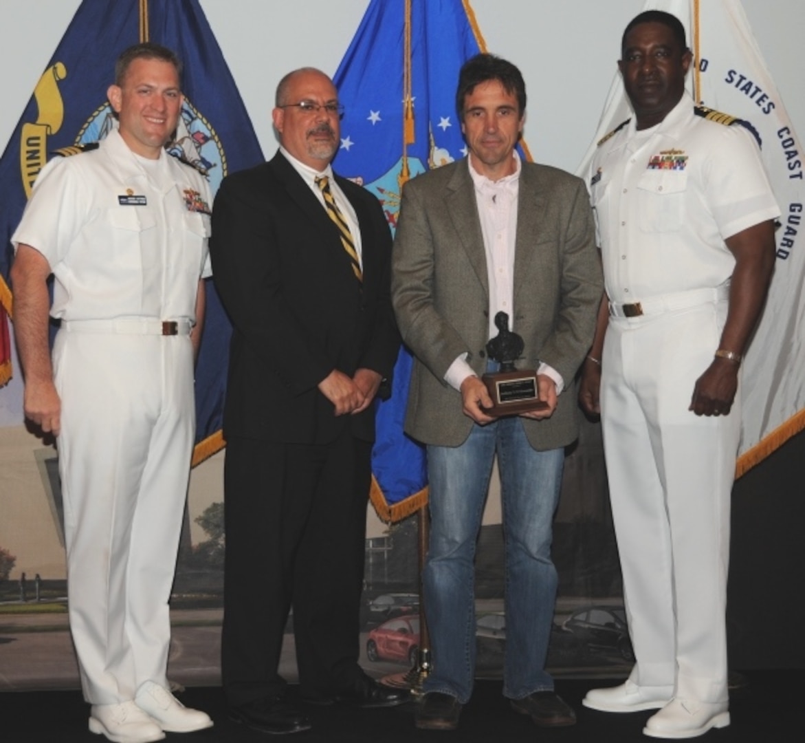 DAHLGREN, Va. (May 17, 2017) - Anthony D'Alessandro holds  the John Adolphus Dahlgren Award moments after receiving it from Naval Surface Warfare Center Dahlgren Division (NSWCDD) leadership at the command's annual honor awards ceremony. D'Alessandro was recognized for the crucial role he played in establishing NSWCDD as the undisputed leader for government designed and developed fire control systems. "Mr. D'Alessandro was a 'founding father' in the architecture and development of the MK 160 Gun Computer System and, throughout his 30 year career at Dahlgren, he has lead numerous other government fire control initiatives, most recently for the 30mm and 105mm Battle Management System gun weapon systems," according to the citation. Standing left to right: Combat Direction Systems Activity Commanding Officer Cmdr. Andrew Hoffman; NSWCDD Technical Director John Fiore; D'Alessandro; and NSWCDD Commanding Officer Capt. Godfrey 'Gus' Weekes.