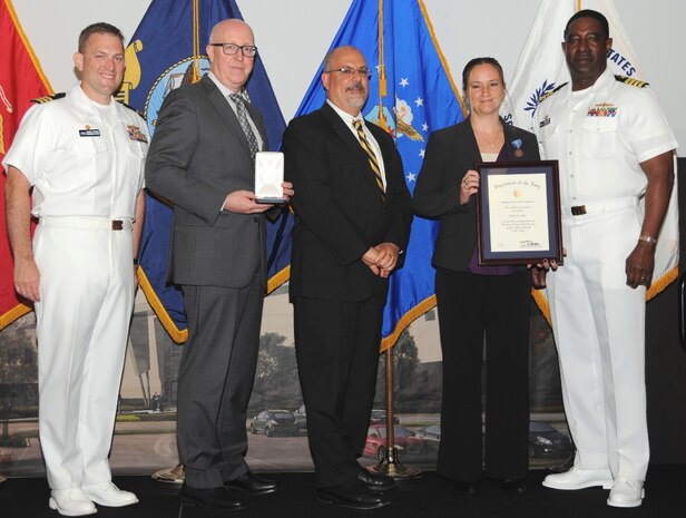 DAHLGREN, Va. (May 17, 2017) - Kathleen Jones holds a framed certificate moments after receiving the Navy Meritorious Civilian Service Award at the Naval Surface Warfare Center Dahlgren Division (NSWCDD) Annual Honor Awards ceremony. Jones was recognized for outstanding, significant, and substantial technical contributions to the Navy in Radar Systems. "Ms. Jones has demonstrated exemplary leadership in expanding her Division's portfolio and developing technically sound leaders to tackle current and future Naval radar challenges," according to the citation, adding that she, "established a culture where mentoring, collaboration, and teambuilding are the norm for developing innovative solutions to novel challenges introduced through the ever-evolving threat." Standing left to right: Combat Direction Systems Activity Commanding Officer Cmdr. Andrew Hoffman; Naval Surface Warfare Center and Naval Undersea Warfare Center Executive Director Donald McCormack; NSWCDD Technical Director John Fiore; Jones; and NSWCDD Commanding Officer Capt. Godfrey 'Gus' Weekes.

