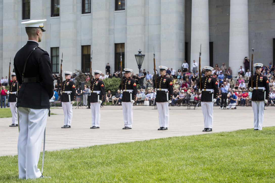 Captain Gregory Jurshak, platoon commander, U.S. Marine Corps Silent Drill Platoon, stands at a ceremonial position while the platoon executes their long line sequence during a Battle Color Ceremony at the Ohio Statehouse, Columbus, Ohio, May 16, 2017. The Marine Corps Battle Color Detachment was invited and hosted by the Speaker of the Ohio House of Representatives, Clifford A. Rosenberger, to tour the Statehouse and perform for members of the House of Representatives and the city of Columbus. In December, the Barracks provided Marines in supporting the public viewing of former Marine, Senator and astronaut, John Glenn, at the Statehouse. In attendance at the Battle Color Ceremony was Glenn’s widow, Annie Glenn, to show her continued support of the beloved Corps.(Official Marine Corps photo by Cpl. Robert Knapp/Released)