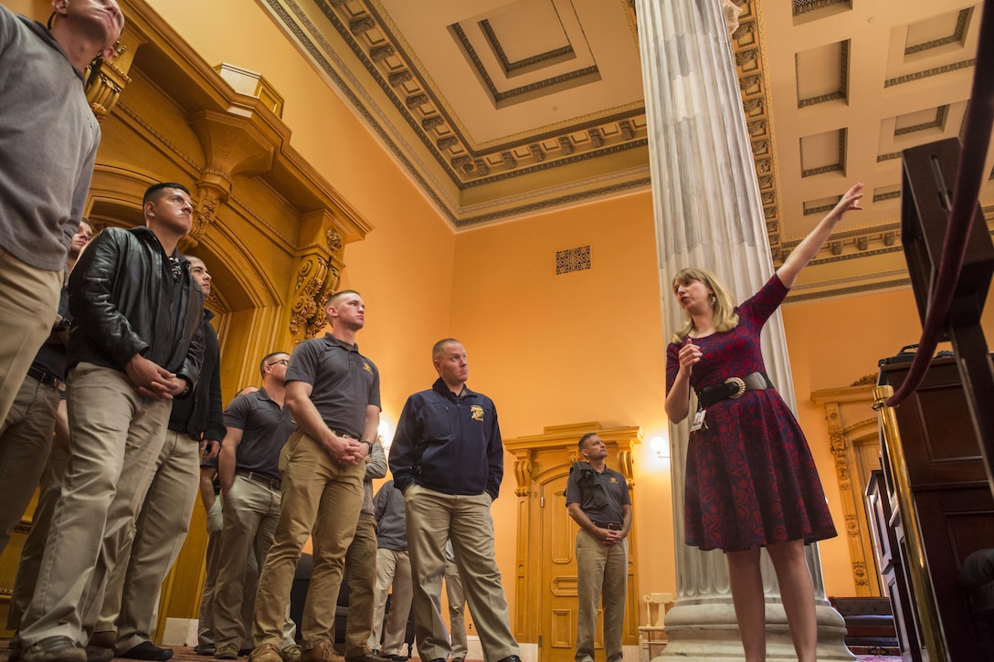 Dayna Jalkanen, deputy director of museum and education, Ohio Statehouse, explains the significance of the Senate Chambers to U.S. Marine Drum & Bugle Corps Marines at the Statehouse, Columbus, Ohio, May 15, 2017. The Marine Corps Battle Color Detachment was invited and hosted by the Speaker of the Ohio House of Representatives, Clifford A. Rosenberger, to tour the Statehouse and perform for members of the House of Representatives and the city of Columbus. In December, the Barracks provided Marines in supporting the public viewing of former Marine, Senator and astronaut, John Glenn, at the Statehouse. In attendance at the Battle Color Ceremony was Glenn’s widow, Annie Glenn, to show her continued support of the beloved Corps. (Official Marine Corps photo by Cpl. Robert Knapp/Released)