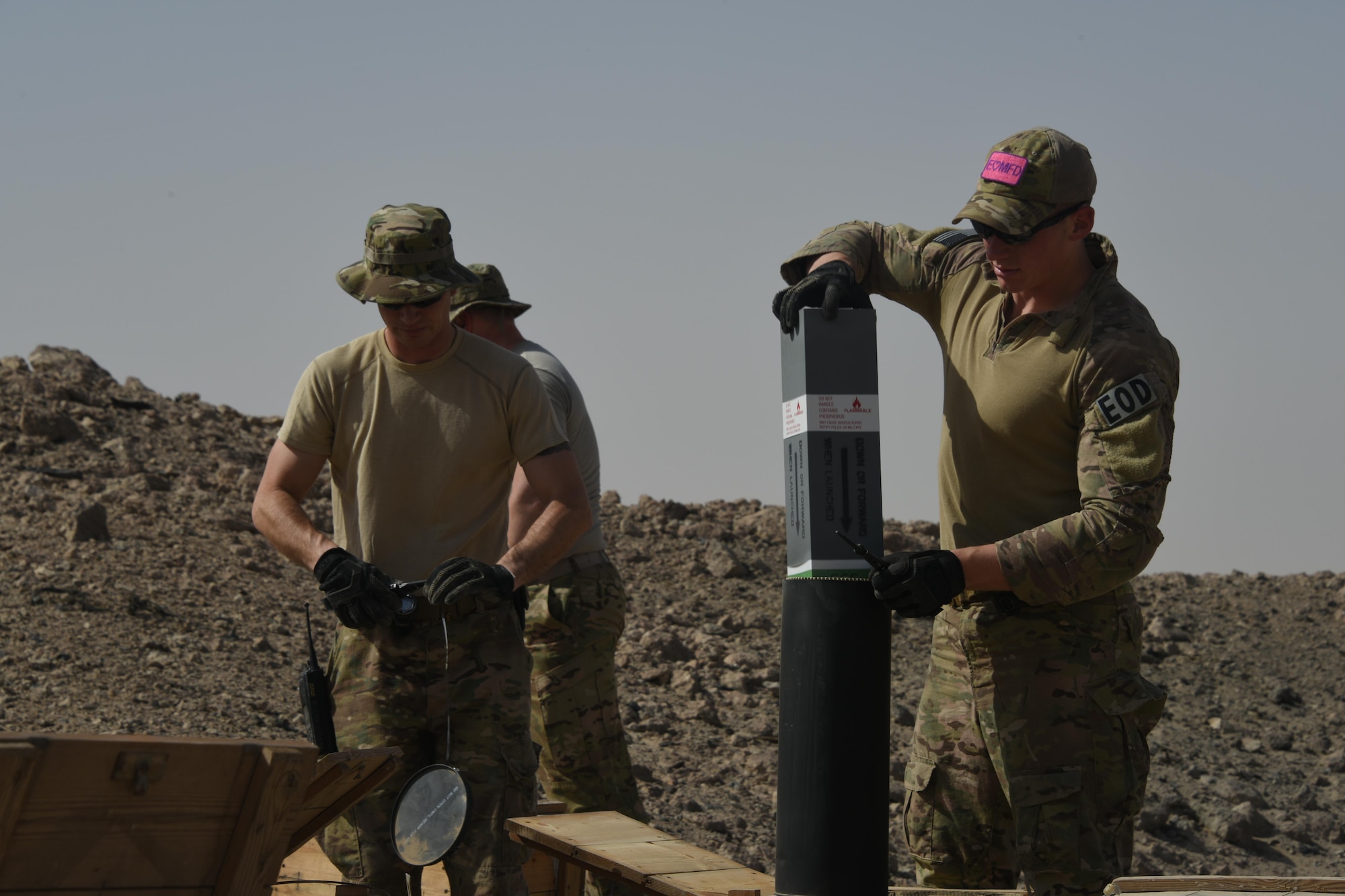 Senior Airman Merit Davey, an Explosive Ordnance Disposal journeyman with the 386th Expeditionary Civil Engineer Squadron, pulls a flare from its canister during an ammunition disposal request burn operation at an undisclosed location in Southwest Asia, May 11, 2017. The stockpile of expired munitions consisting primarily of flares was transported to an isolated location where the unserviceable items were stacked in a man-made hole in preparation for destruction. (U.S. Air Force photo/ Tech. Sgt. Jonathan Hehnly)