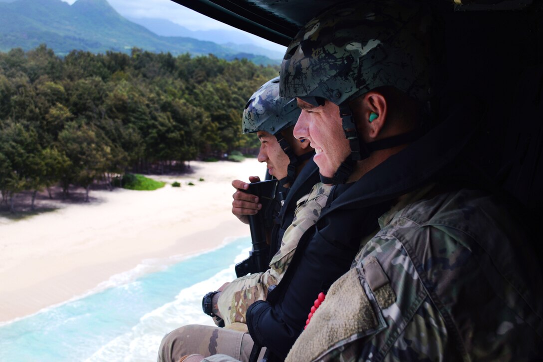 Soldiers ride in a Marine Corps UH-1Y Huey helicopter along the eastern Oahu coastline, Hawaii, May 16, 2017, during helocast insertion training. Army photo by Staff Sgt. Armando R. Limon