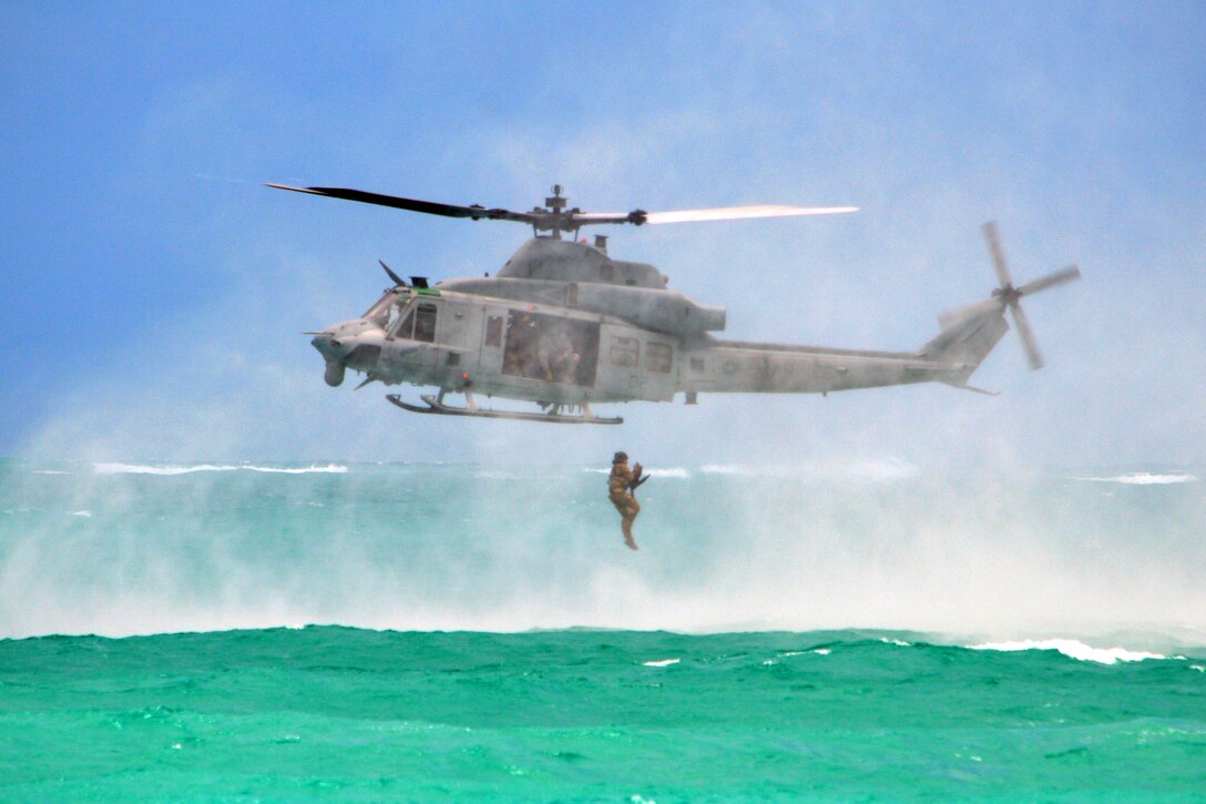 A soldier jumps from a Marine Corps UH-1Y Huey helicopter into the Pacific Ocean, May 16, 2017, during helocast insertion training. Army photo by Staff Sgt. Armando R. Limon