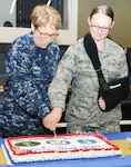 Rear Adm. Rebecca McCormick-Boyle (left), commander, Navy Medicine Education, Training and Logistics Command, cuts a ceremonial cake with Staff Sgt. Kaitlyn Montenegro during a celebration for National Nurses Week at the Medical Education and Training Campus at Joint Base San Antonio-Fort Sam Houston May 11. Navy and Air Force nurses and medical technicians participated together in several health promotions activities throughout the week to commemorate Nurses Week. 