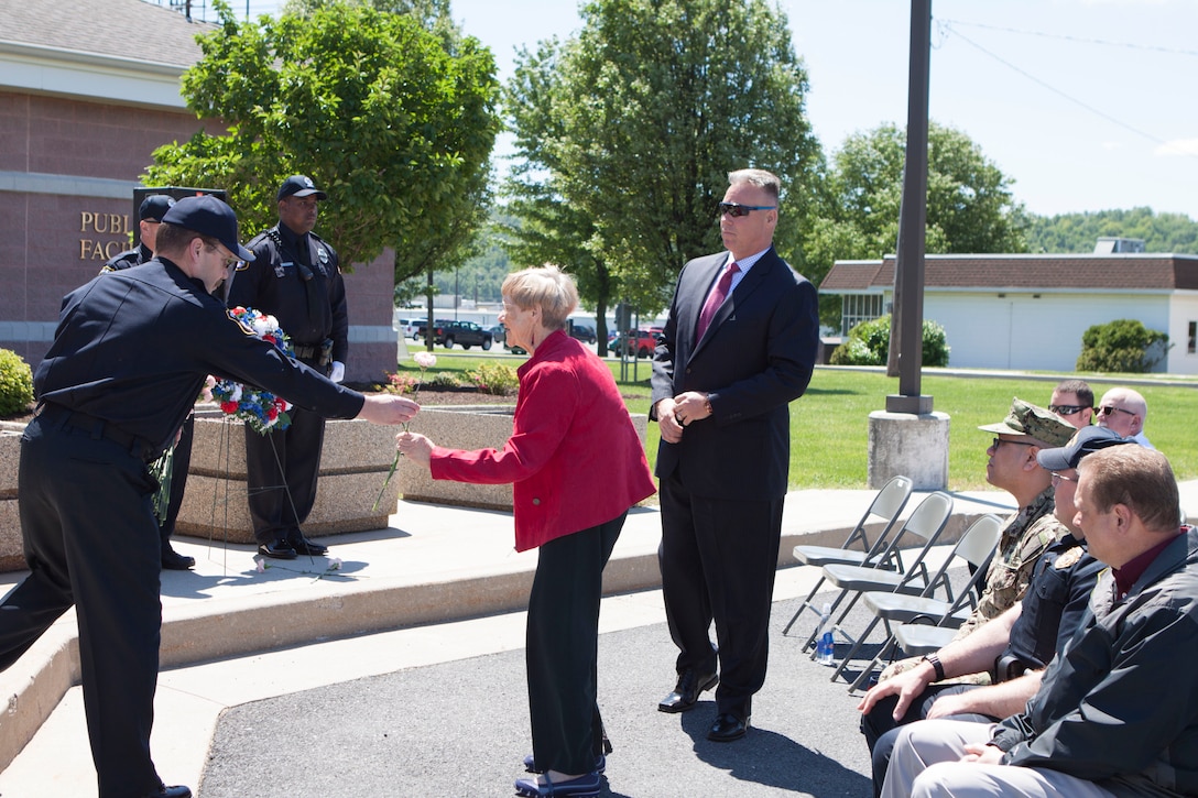 D.J. Landis (center), mayor of New Cumberland, Pennsylvania takes the opportunity to place a pink carnation in front of the wreath in honor of the fallen officers at the DLA Distribution National Police Week wreath laying ceremony held on May 15.