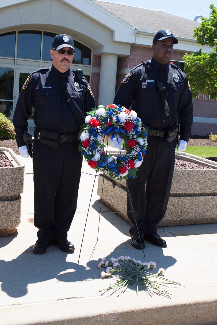 DLA police officers James Powers, Jr. (left) and Durran Topp, Jr. (right) stand guard of the memorial wreath and carnations during the DLA Distribution National Police Week wreath laying ceremony held on May 15.