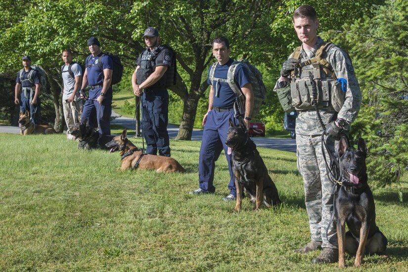 Military and local law enforcement K-9 handlers stand with their working dogs before the 2017 National Police Week military working dog Iron Dog Competition at Joint Base Andrews, Md., May 16, 2017. In 1962, President John F. Kennedy signed a proclamation which made May 15, Peace Officers Memorial Day, and the week of Police Week. This is a time to honor and thank the law enforcement officers who serve for their dedication and service to the community. (U.S. Air Force photo by Airman 1st Class Valentina Lopez)