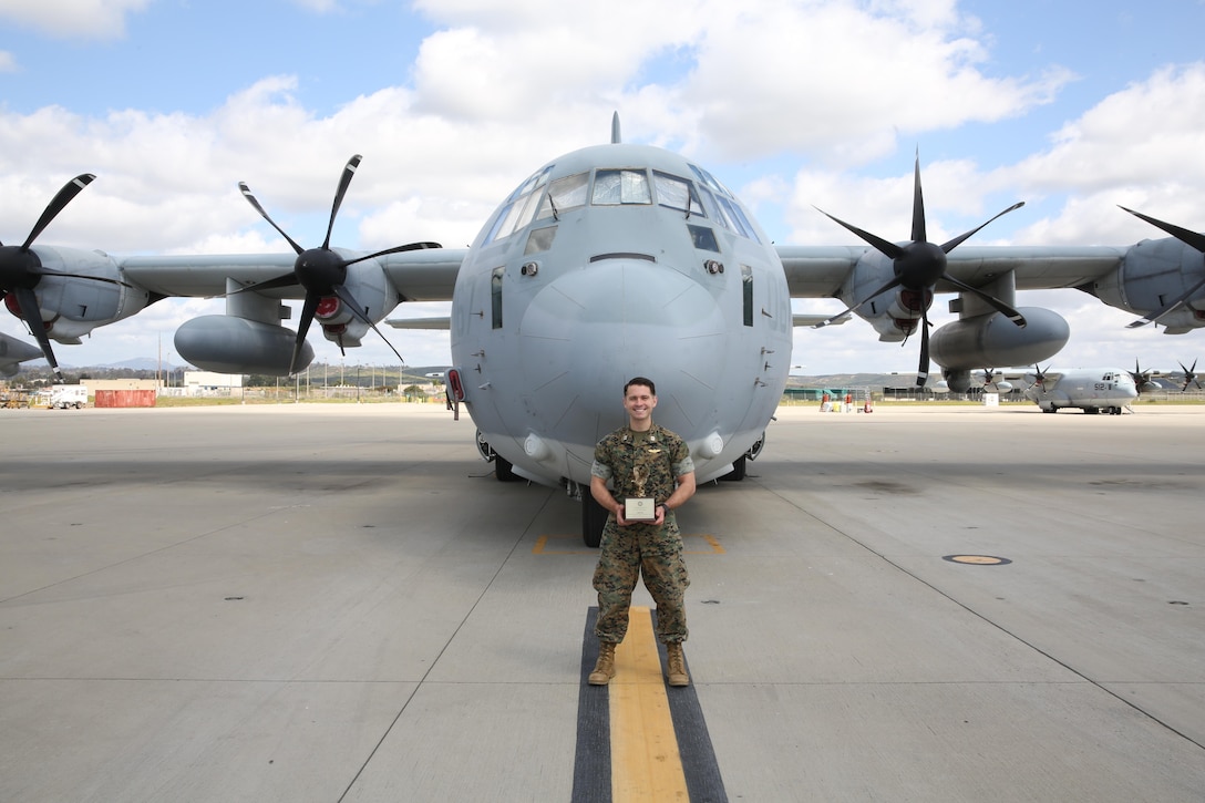 Capt. Christopher Lavergne, a KC-130J Super Hercules pilot with Marine Aerial Refueler Transport Squadron (VMGR) 352, proudly displays the 2017 Marine Corps Aviation Association Henry Wildfang award in front of a KC-130J at Marine Corps Air Station Miramar, Calif., March 27. VMGR-352 received the Henry Wildfang award for successful mission accomplishments and the most mishap free hours. (U.S. Marine Corps photo by Lance Cpl. Jake M.T. McClung/Released)