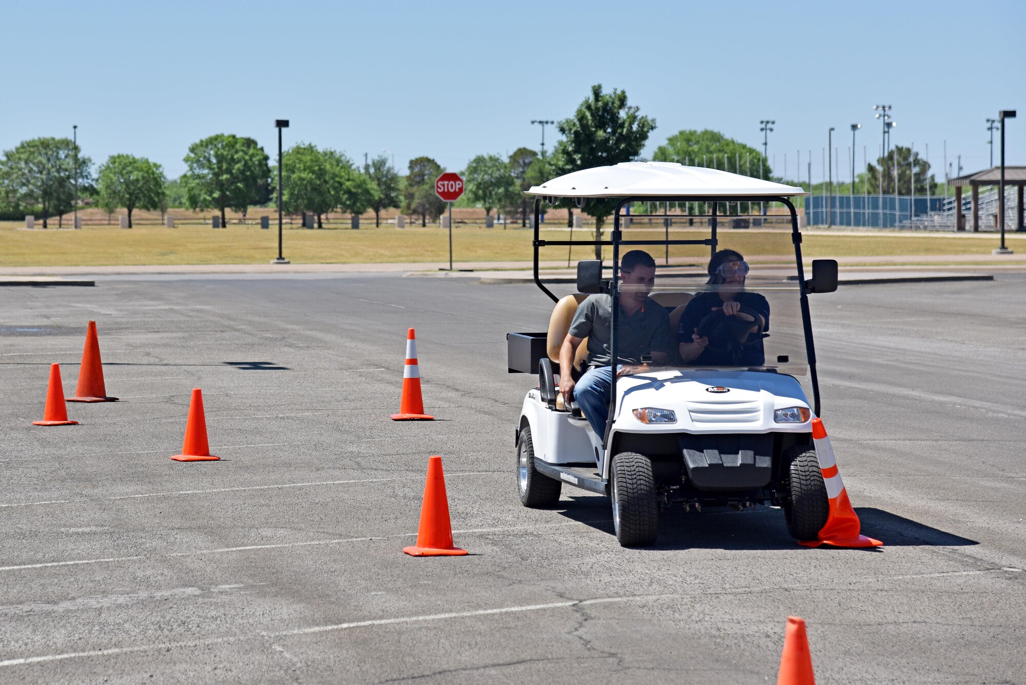 Tiffanie De La Cruz, Goodfellow Exchange junior manager, drives a golf cart during a simulated drunk driving course for Police Week at the commissary on Goodfellow Air Force Base, Texas, May 17, 2017. The 17th Security Forces Squadron held the course to raise awareness on drunk driving and the dangers it can cause. (U.S. Air Force photo by Staff Sgt. Joshua Edwards/Released)