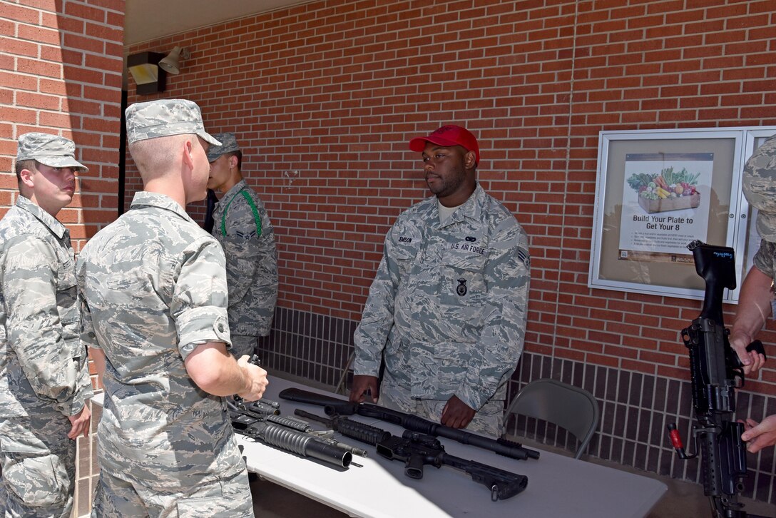 Senior Airman Devin Jemison, 17th Security Forces Squadron combat arms instructor, tells Airmen about different Air Force weaponry at the commissary on Goodfellow Air Force Base, Texas, May 17, 2017. As part of Police Week, the 17th SFS gave back to the base by providing displays and demonstrations. (U.S. Air Force photo by Staff Sgt. Joshua Edwards/Released)