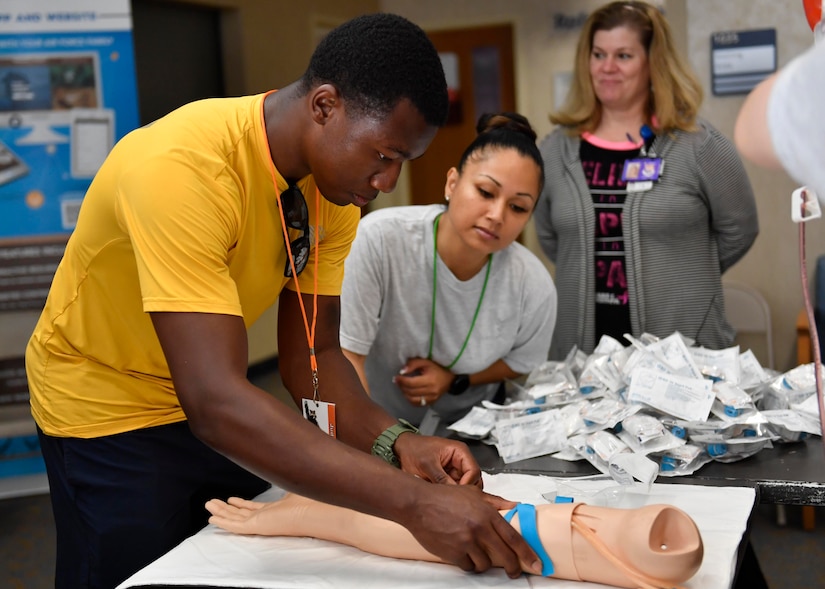 U.S. Navy Petty Officer 3rd Class Khaled Moore, left, Naval Health Clinic Charleston hospital corpsman, practices starting an IV during the second annual Lowcountry Medical Skills Expo here, May 17, 2017. Nearly 300 people from eight agencies trained on nine medical competencies including sutures, mass blood transfusions, IVs and litter carrying techniques during the expo.