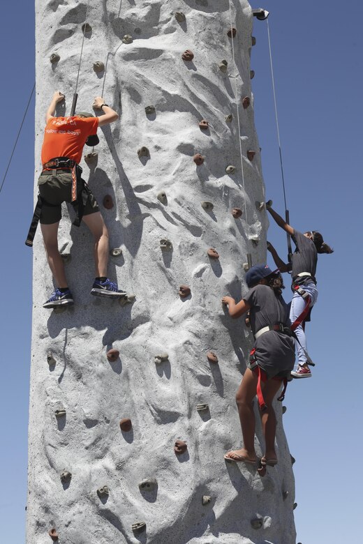 Kids climb a rock wall during the annual We Salute You Fest at Victory Field aboard the Marine Corps Air Ground Combat Center, Twentynine Palms, Calif., May 13, 2017. Marine Corps Community Services hosts the event to show their appreciation for all the hard working service members who protect this country.