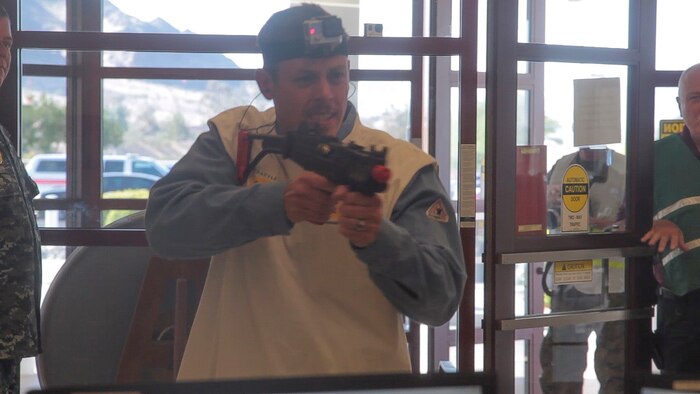 A simulated active shooter aims a fake weapon during an Active Shooter Full Scale Exercise at Robert E. Bush Naval Hospital, aboard Marine Corps Air Ground Combat Center Twetynine Palms, Calif., May 16, 2017. The exercise allowed for the naval hospital, Provost Marshals Office, Fire Department and Naval Criminal Investigative Service to practice and assess their ability to detect, identify and respond to an active shooter incident, validating emergency response procedures. (U.S. Marine Corps photo by Cpl. Thomas Mudd)
