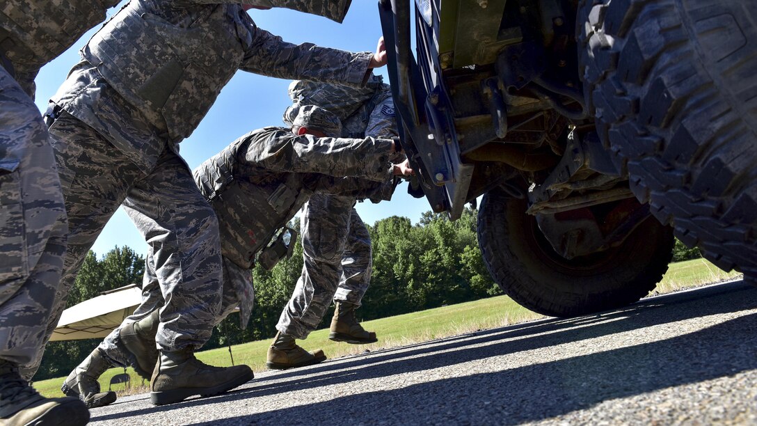 Airmen push a Humvee during the Defender Challenge at Little Rock Air Force Base, Ark., May 15, 2017. The base held the team competition, which also included a four-mile ruck march, buddy carries and a blindfold weapon dismantling contest, to kick off Police Week 2017. Air Force photo by Staff Sgt. Jeremy McGuffin