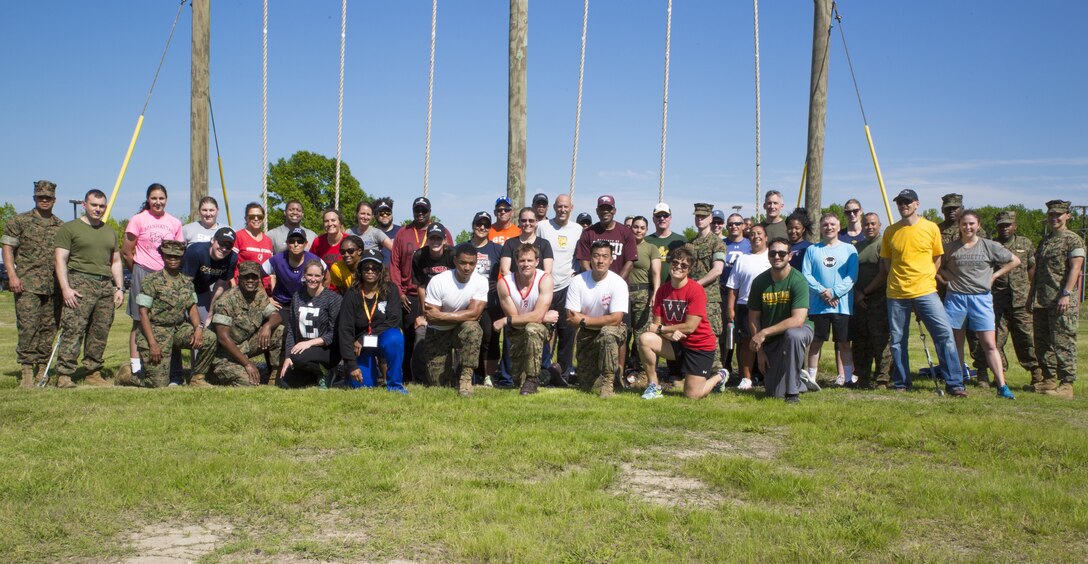 Approximately 35 collegiate coaches pose for a picture with Marines and Physical Training Instructors aboard Officer Candidates School, Marine Corps Base Quantico, Va., May 18, 2017. The coaches travelled from across the United States to MCB Quantico to learn about Marine Corps leadership, the Corps' officer programs and how Marines train and develop its officers. The workshop creates mutually beneficial relationships between America's coaches and the Marine Corps, where coaches take what they have learned based on first-hand experiences and share it with their athletes.