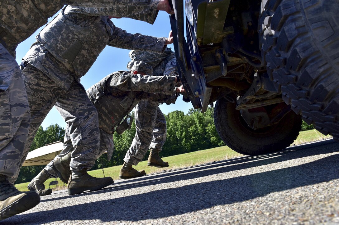 Airmen push a Humvee during the Defender Challenge at Little Rock Air Force Base, Ark., May 15, 2017. The base held the team competition, which also included a four-mile ruck march, buddy carries and a blindfold weapon dismantling contest, to kick off Police Week 2017. Air Force photo by Staff Sgt. Jeremy McGuffin