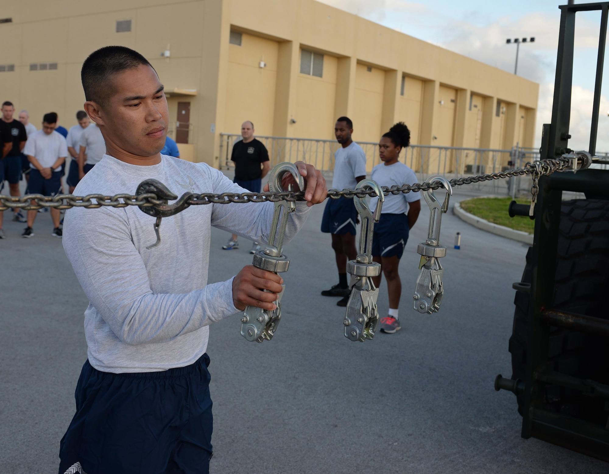 An Airman attaches an MB-1 device onto a chain during the Port Dawg’s memorial May 19, 2017, at Andersen Air Force Base, Guam. The MB-1 device symbolizes one of the five aerial transportation specialists that passed away across the Air Force within the last year. (U.S. Air Force photo by Senior Airman Alexa Ann Henderson)