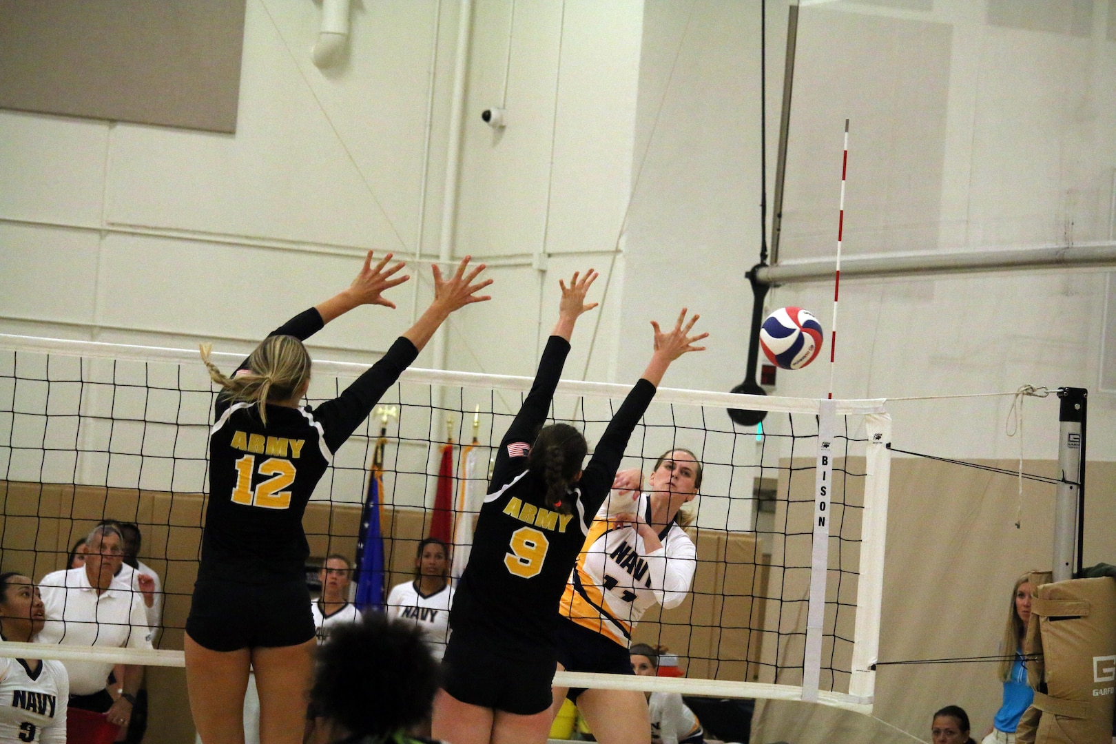 Navy Lieut. Katerine Bray of Pearl Harbor, Hawaii hits past two Army defenders in match 3 of the 2017 Armed Forces Women's Volleyball Championship at Naval Station Mayport, Florida on 18 May.