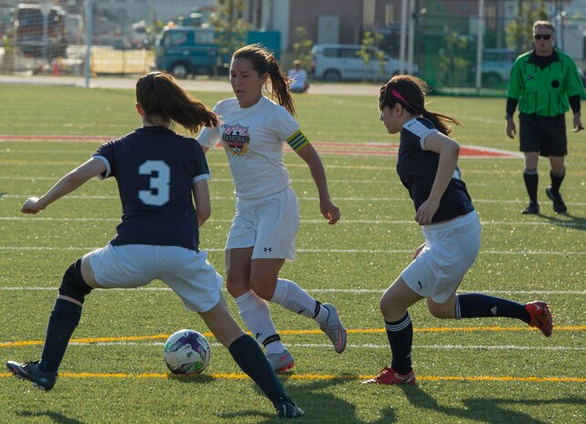 Two girls from the International School of the Sacred Heart soccer team attempt to secure the ball from Bobbi Hill, a Matthew C. Perry senior and captain of the Lady Samurai soccer team, during the 2017 Girls Division II Far East Soccer Tournament at Marine Corps Air Station Iwakuni, Japan, May 18, 2017. International and Department of Defense Education Activity high school teams from all over Japan made up the four-day, 32-game tournament with M.C. Perry winning the championship against Sacred Heart 2-0. Hill scored an unprecedented 16 goals throughout the tournament. (U.S. Marine Corps photo by Pfc. Stephen Campbell)