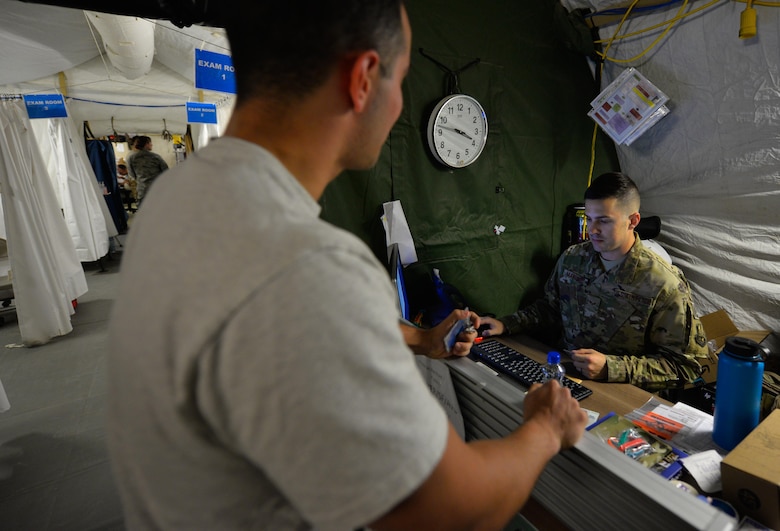 U.S. Air Force Senior Airman Jeffrey Mangione, a medical technician assigned to the 332nd Expeditionary Medical Group, checks in a patient at the reception area of the Expeditionary Medical Support System tent May 10, 2017, in Southwest Asia. The 332nd EMDG medical staff will transfer from the mobile tent unit to a new permanent clinic facility, marking the last EMEDS tent to close in the Air Force Central Command region. (U.S. Air Force photo by Staff Sgt. Alexander W. Riedel)