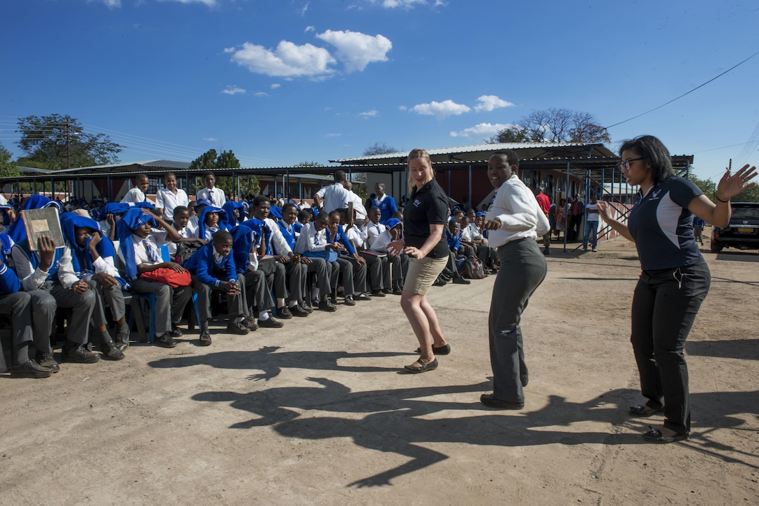 Staff Sgt. Jill Diem, U.S. Air Forces in Europe Band vocalist, and Capt. Mesha Nelson, USAFE-AFAFRICA public affairs officer, dance with a student from the Chobe Junior Secondary School during a band performance at the school in Kasane, Botswana on May 15, 2017. While supporting the 2017 African Air Chiefs Symposium, the USAFE “Ambassadors Combo” performance band partnered with the Botswana Defence Force band to perform several concerts at schools in northern Botswana to inspire the students through the universal language of music. The U.S. And Botswana are co-host of this year's symposium. (U.S. Air Force photo by Staff Sgt. Krystal Ardrey)