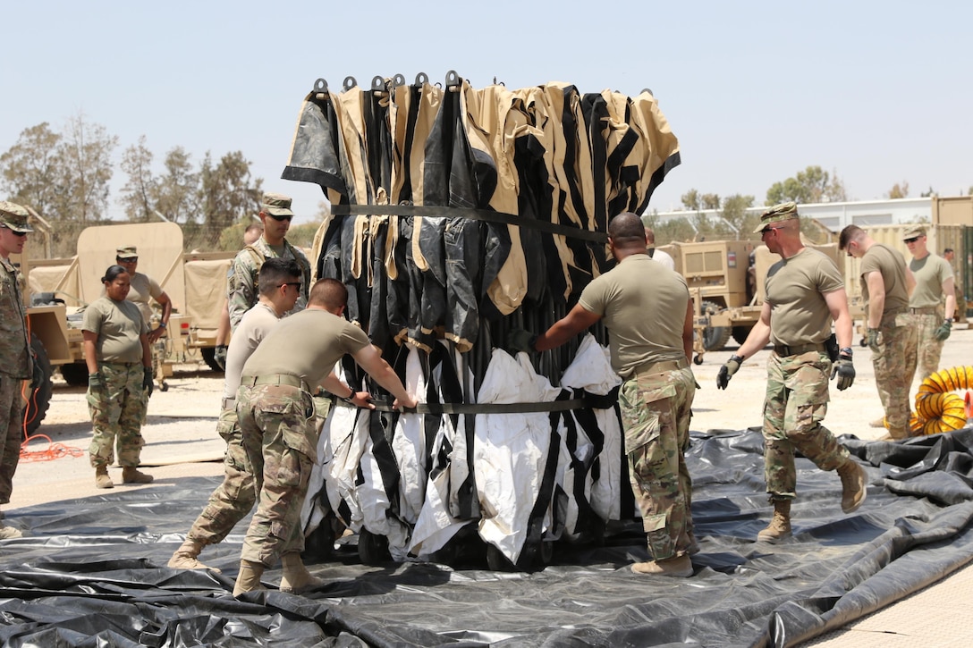 USARCENT Soldiers prepare the contingent command post tactical operations center’s main tent during the May 4th set up for Exercise Eager Lion in Jordan. (U.S. Army Photo by Cadet James Mason)