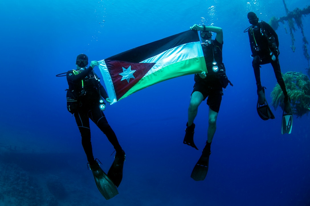 Divers from the Royal Jordanian Navy pose for a photo holding their nation’s flag during Exercise Eager Lion 2017. Eager Lion is an annual U.S. Central Command exercise in Jordan designed to strengthen military-to- military relationships between the U.S., Jordan and other international partners. This year's iteration is comprised of about 7,200 military personnel from more than 20 nations that will respond to scenarios involving border security, command and control, cyber defense and battlespace management. (U.S. Navy Combat Camera photo by Mass Communication Specialist 2nd Class Austin L. Simmons)