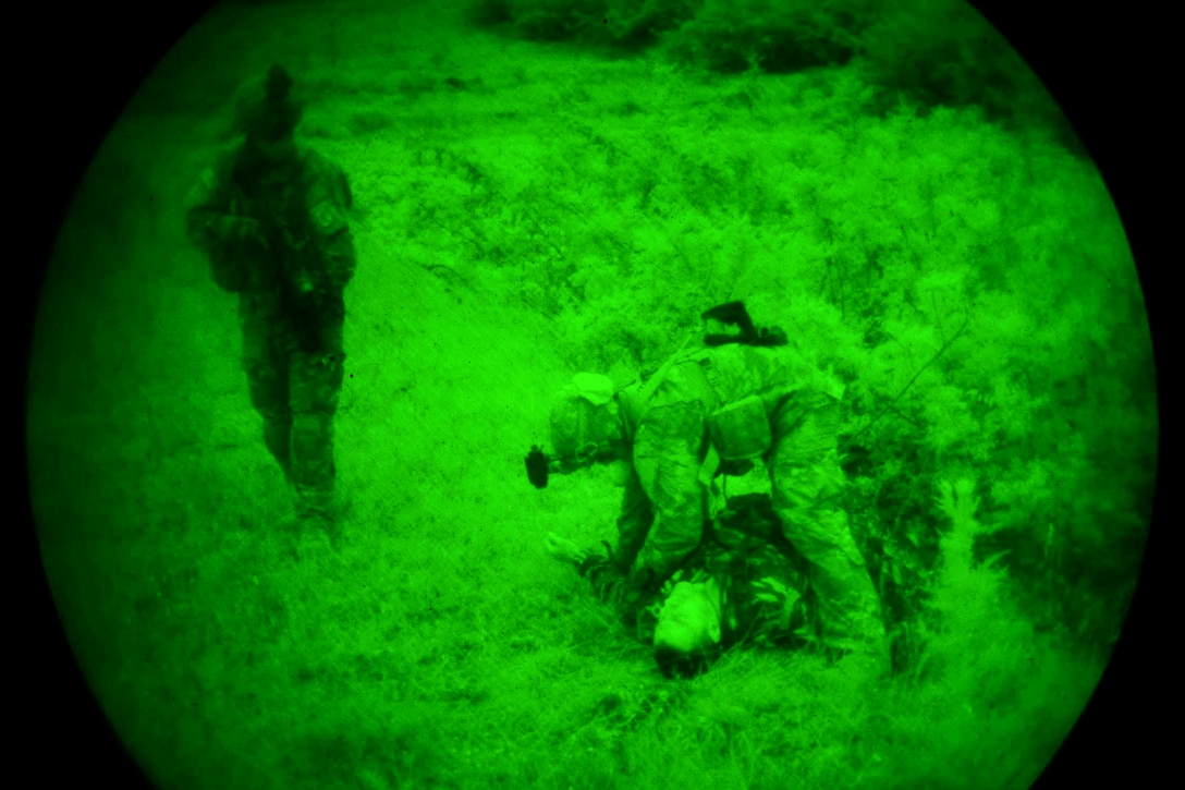 As seen through a night-vision lens, a U.S. soldier provides medical aid to a mock casualty during a night raid on an enemy camp while participating in Bayonet-Minotaur Exercise 2017 in Thessaloniki, Greece, May 17, 2017. Army photo by Graigg Faggionato